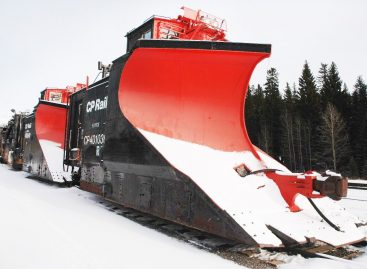 Мощные поезда рассекают горы снега